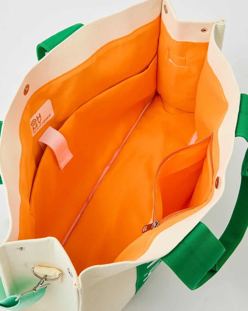 Green Mahj It All bag interior with orange lining and zip pocket