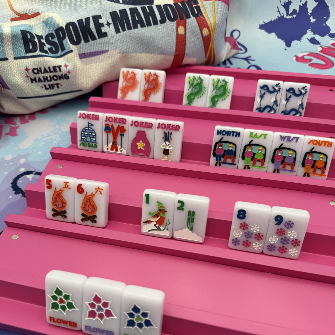 The Chalet Frosty Lilac tiles on pink racks with the Chalet Mahjong Lift tile bag; racks and mat sold separately