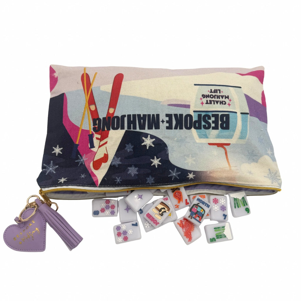 Chalet Mahjong Lift tile bag with The Chalet Frosty Lilac tiles spilling out and the purple puffy heart zipper pull