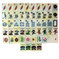 One of each Grateful Dead x Bespoke Mahjong Sunshine Daydream Tie Dye Pearl tile: lightning-bolt craks, dancing-skeleton bams, Steal Your Face dots, Dancing Bear jokers, named flowers, and tour-bus winds on pale yellow pearl