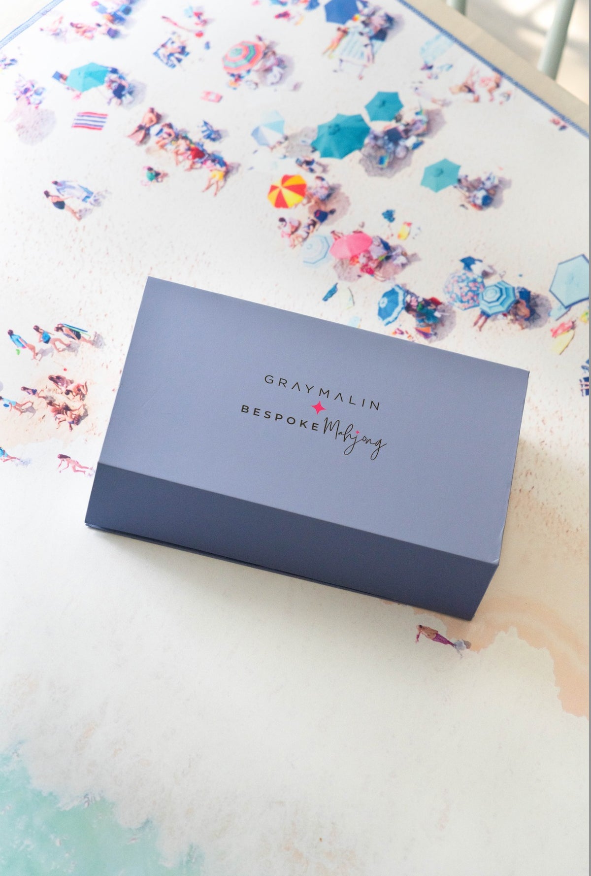 Gray Malin x Bespoke Mahjong blue product box on a beach-print mat; mat sold separately