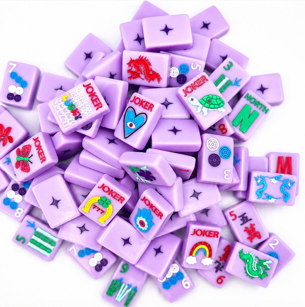 Pile of Lucky Charms French Lavender tiles showing evil-eye, turtle, and rainbow jokers, dragons, and the diamond-logo backs