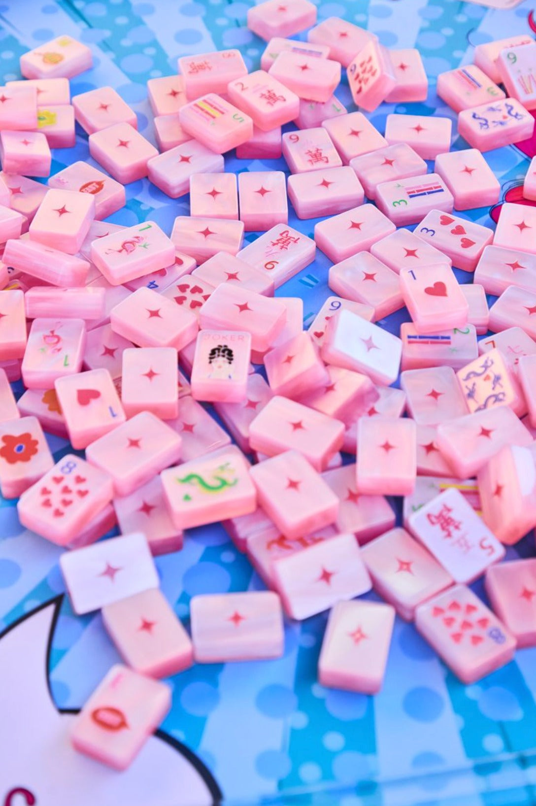 Pop Diva Cotton Candy Pink Pearl tiles scattered face up and face down on a blue pop-art mat; mat sold separately