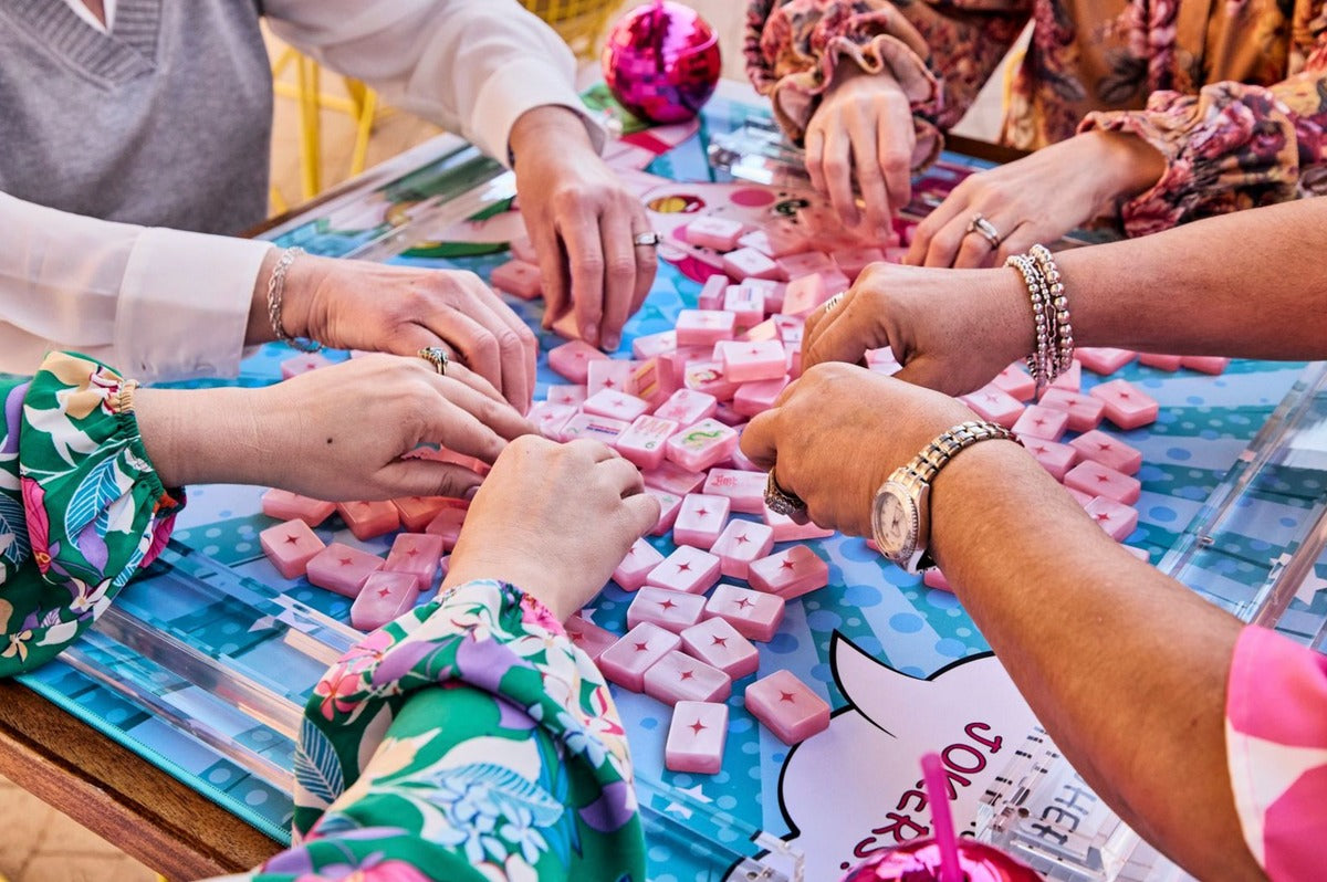 Four players mixing Pop Diva Cotton Candy Pink Pearl tiles on a pop-art mat; mat sold separately