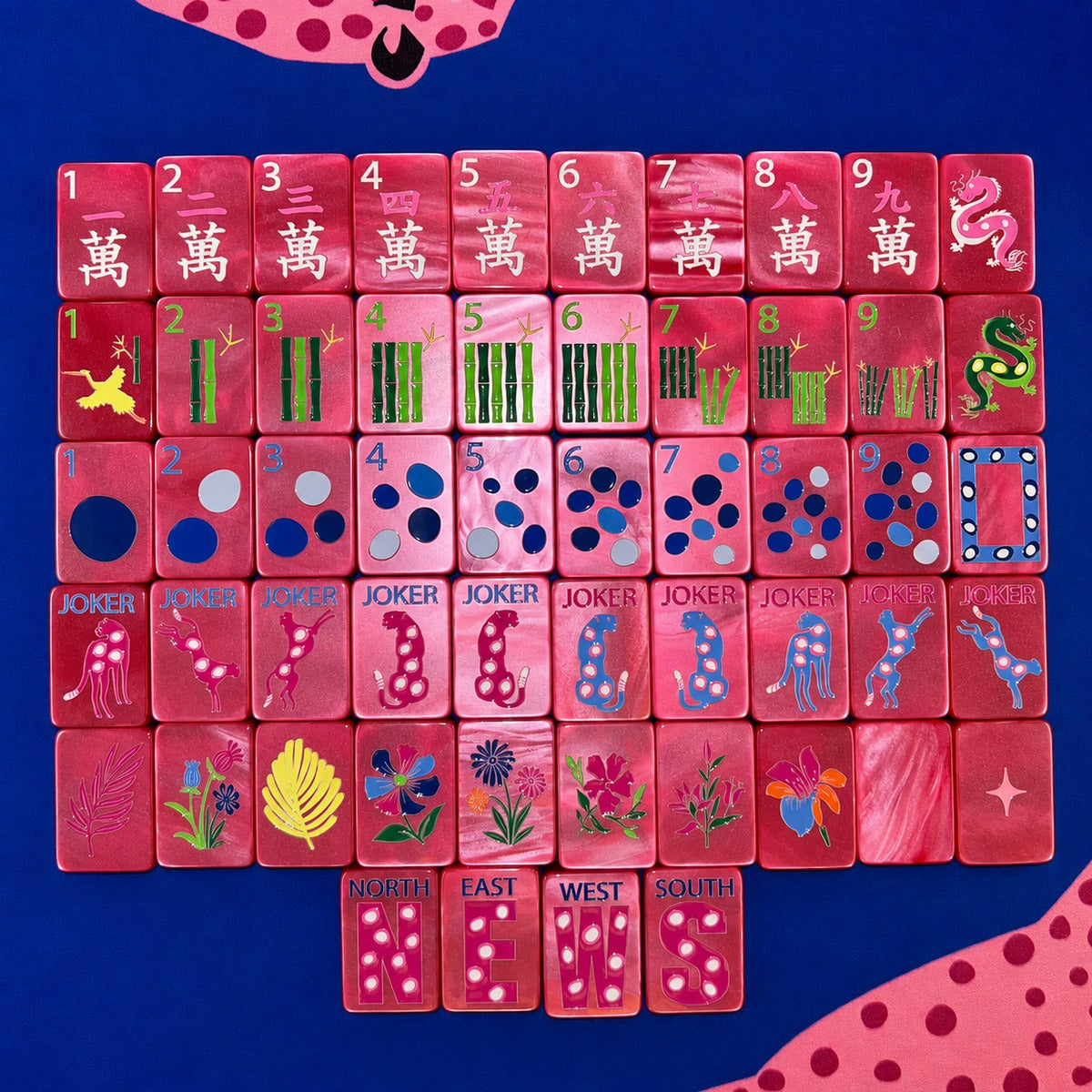 One of each Bespoke Mahjong Springtime Safari Wild Pink Pearl tile: white-character craks, bamboo bams, multicolor dots, cheetah jokers, tropical flowers, and NEWS winds on hot pink pearl