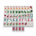 One of each Bespoke Mahjong Springtime Safari Bright White tile: pink craks, bamboo bams, multicolor dots, cheetah jokers, tropical flowers, and NEWS winds on white