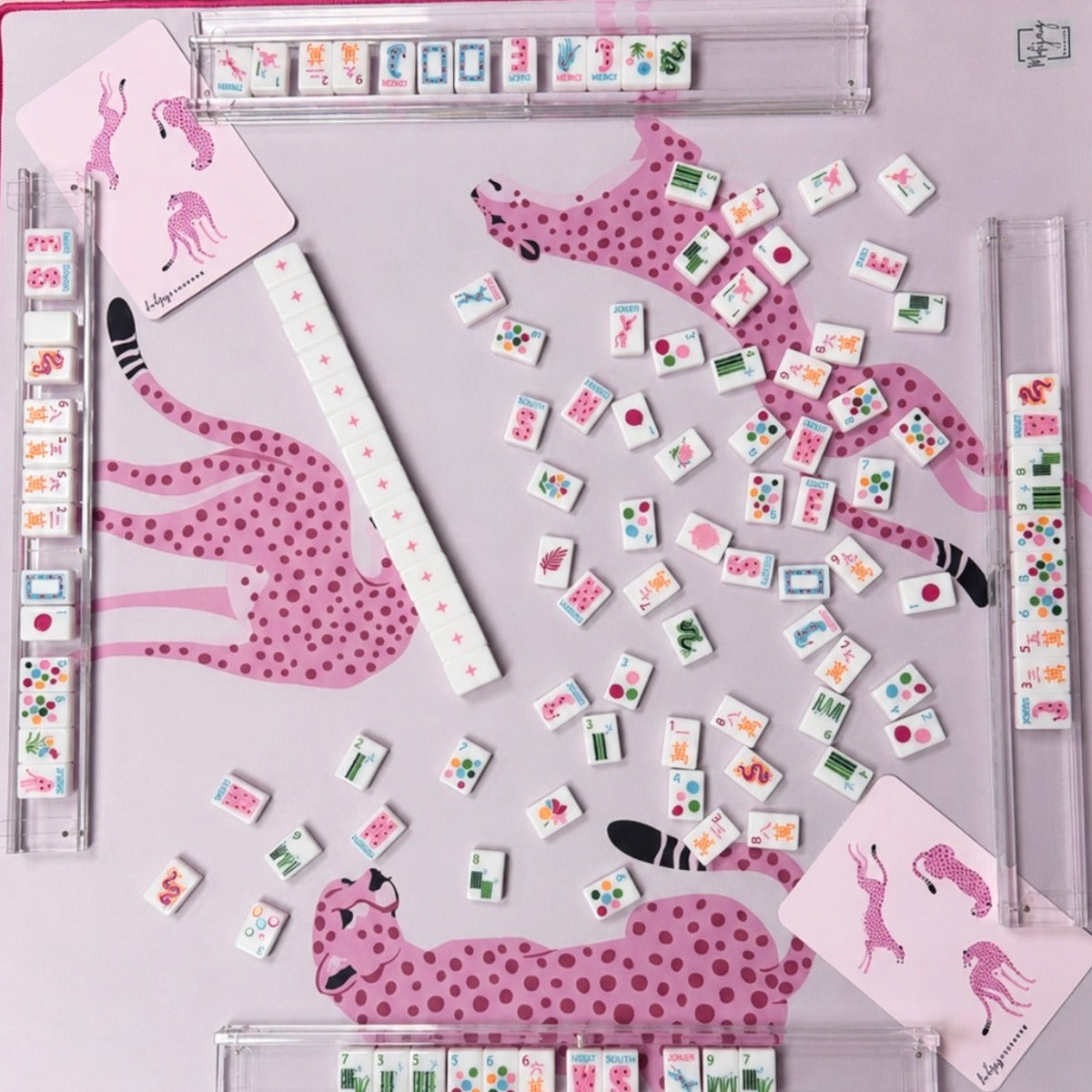 Overhead view of Springtime Safari Bright White tiles on a pink cheetah mat with clear racks; racks and mat sold separately