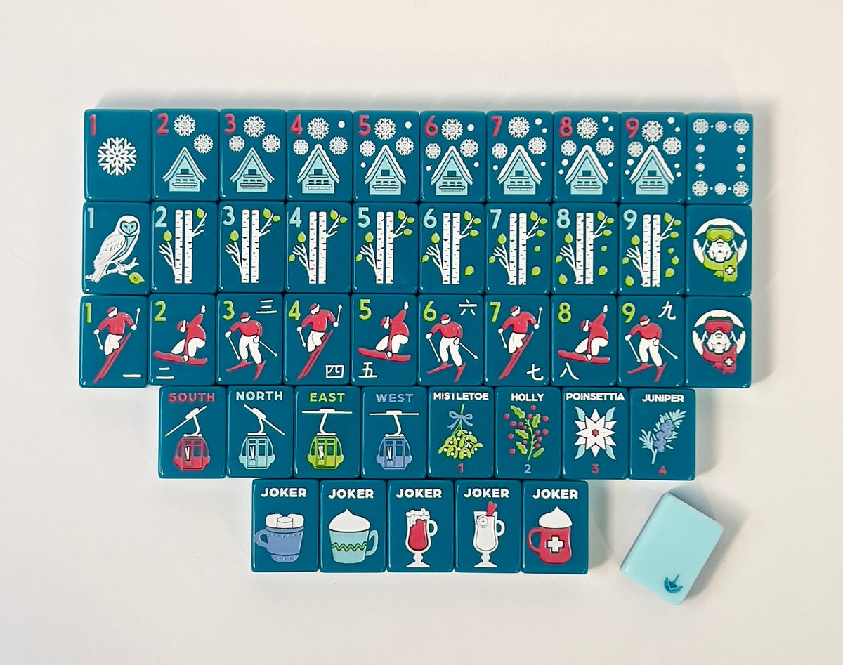 One of each Charleston Mahjong Club Après Ski Club tile face laid out in rows: chalet dots, birch bams, skier craks, gondola winds, winter flowers, and hot-drink jokers, with a light teal tile back