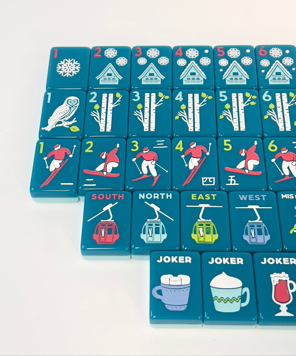 Angled close-up of Après Ski Club tiles showing snowy chalet dots, birch bams, skier craks, gondola winds, and mug jokers