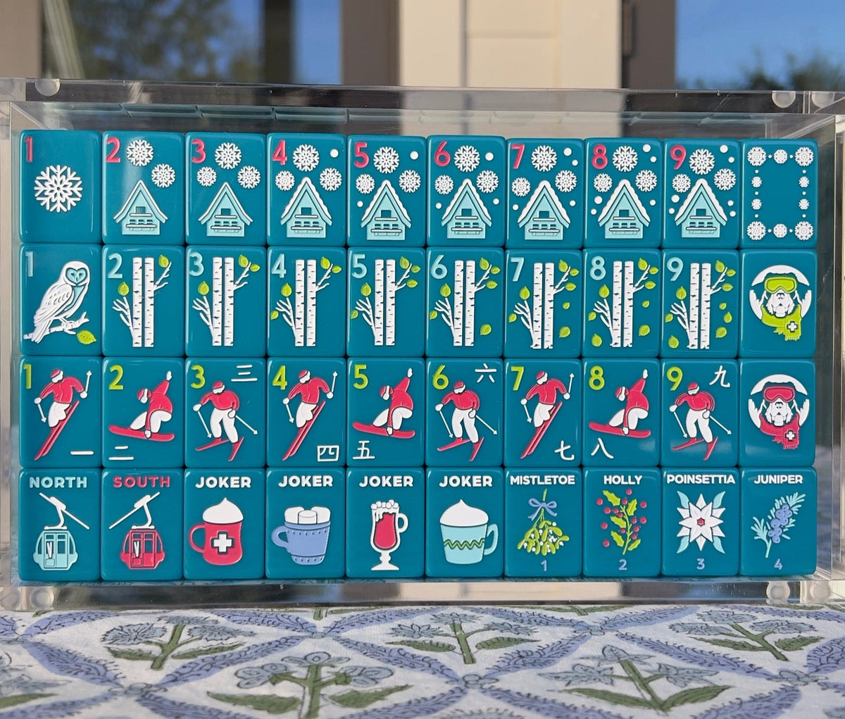 Après Ski Club tiles arranged in a clear acrylic display box outdoors; display box sold separately