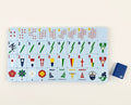 One of each Charleston Mahjong Club Yacht Club tile face laid out in rows: lifesaver dots, oar bams, signal-flag craks, flowers, catamaran winds, and mermaid and sailor jokers, with a navy tile back