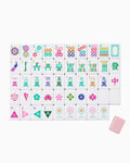 One of each Oh My Mahjong La Fete tile face laid out in rows: dots, bams, craks, flowers, winds, and jokers, with a blush pink tile back