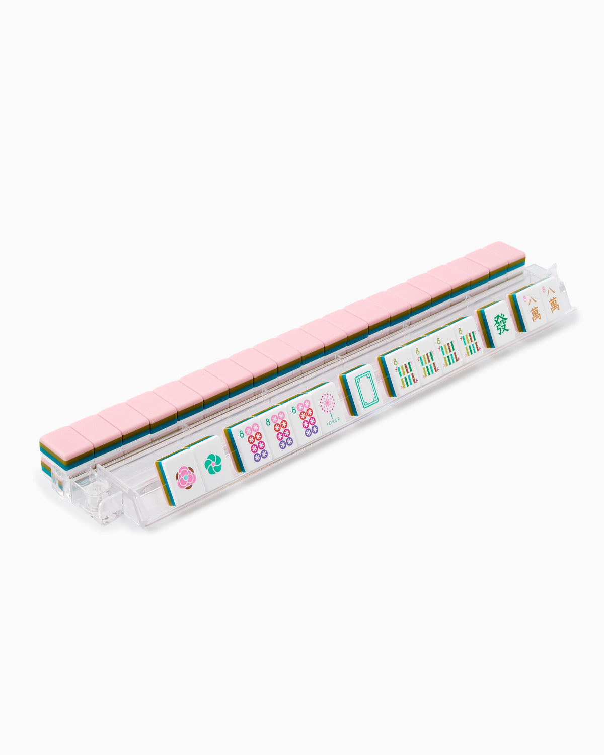 La Fete mahjong tiles on a clear acrylic rack, a row of face-up tiles in front and blush pink tile backs lined up behind