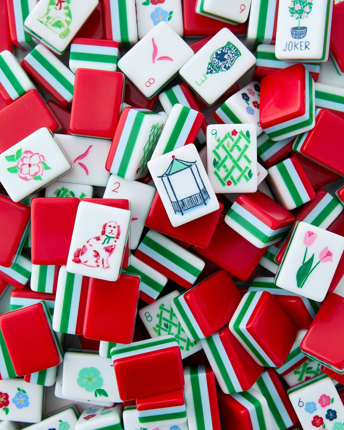 Oh My Mahjong Nantucket tiles piled loosely, red backs striped with green and white beside white tile faces