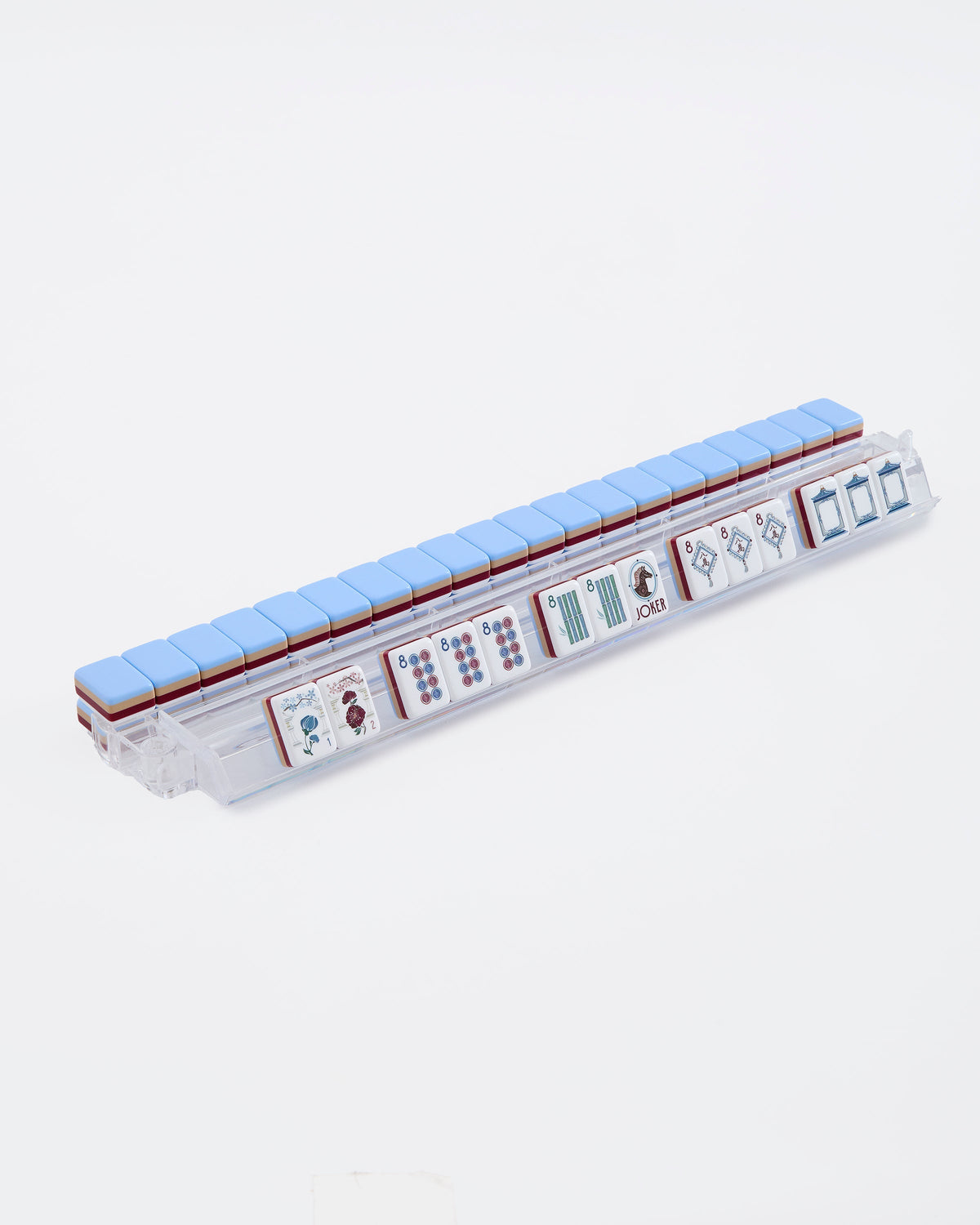 Osler mahjong tiles on a clear acrylic rack, a row of face-up tiles in front and pale blue tile backs lined up behind