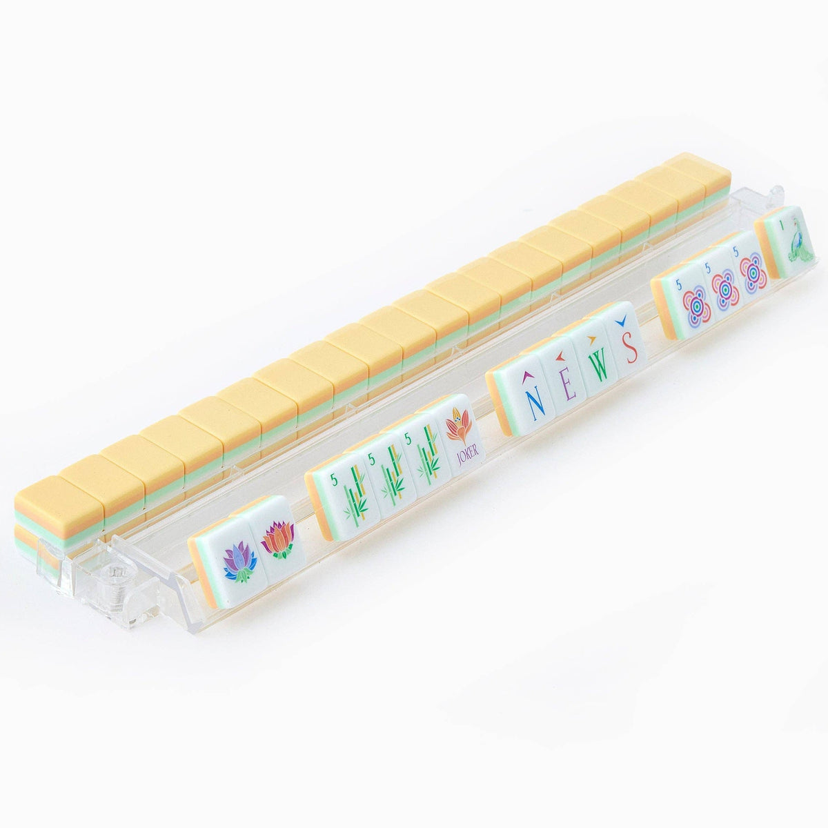 Sorbet mahjong tiles on a clear acrylic rack, a row of face-up tiles in front and butter yellow tile backs lined up behind