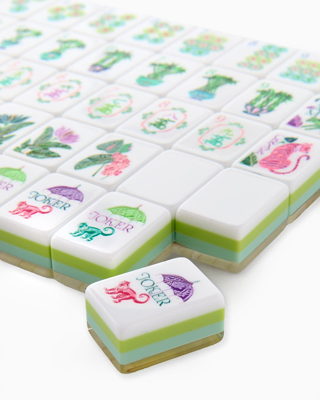 Close-up of Palm Royale joker tiles with a monkey under a parasol, showing the layered green and aqua tile edges