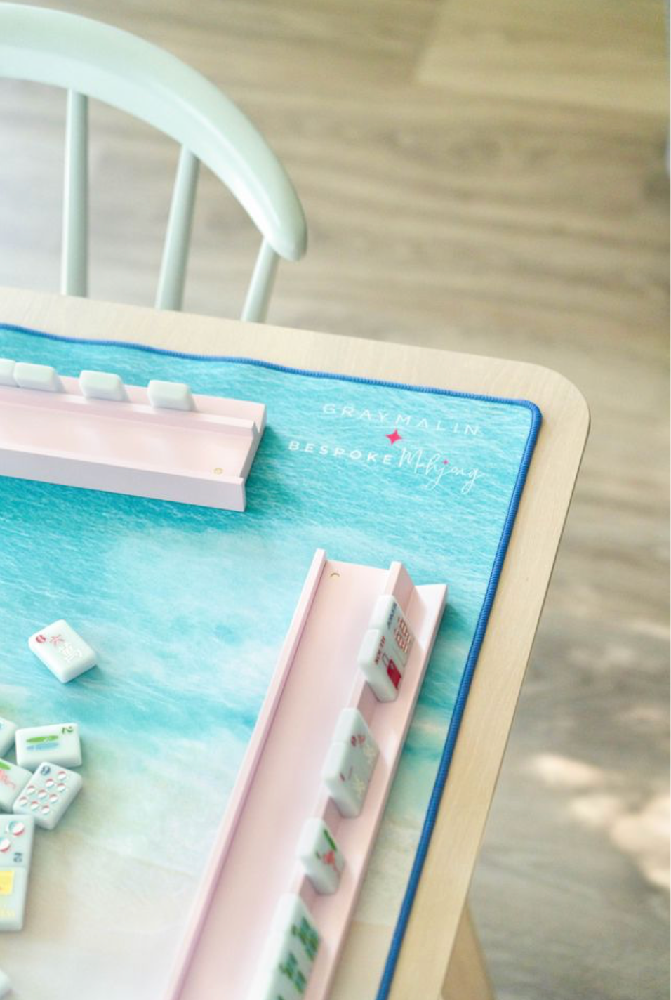 Gray Malin Beach Club mat on a table with pink racks and tiles; tiles and racks sold separately