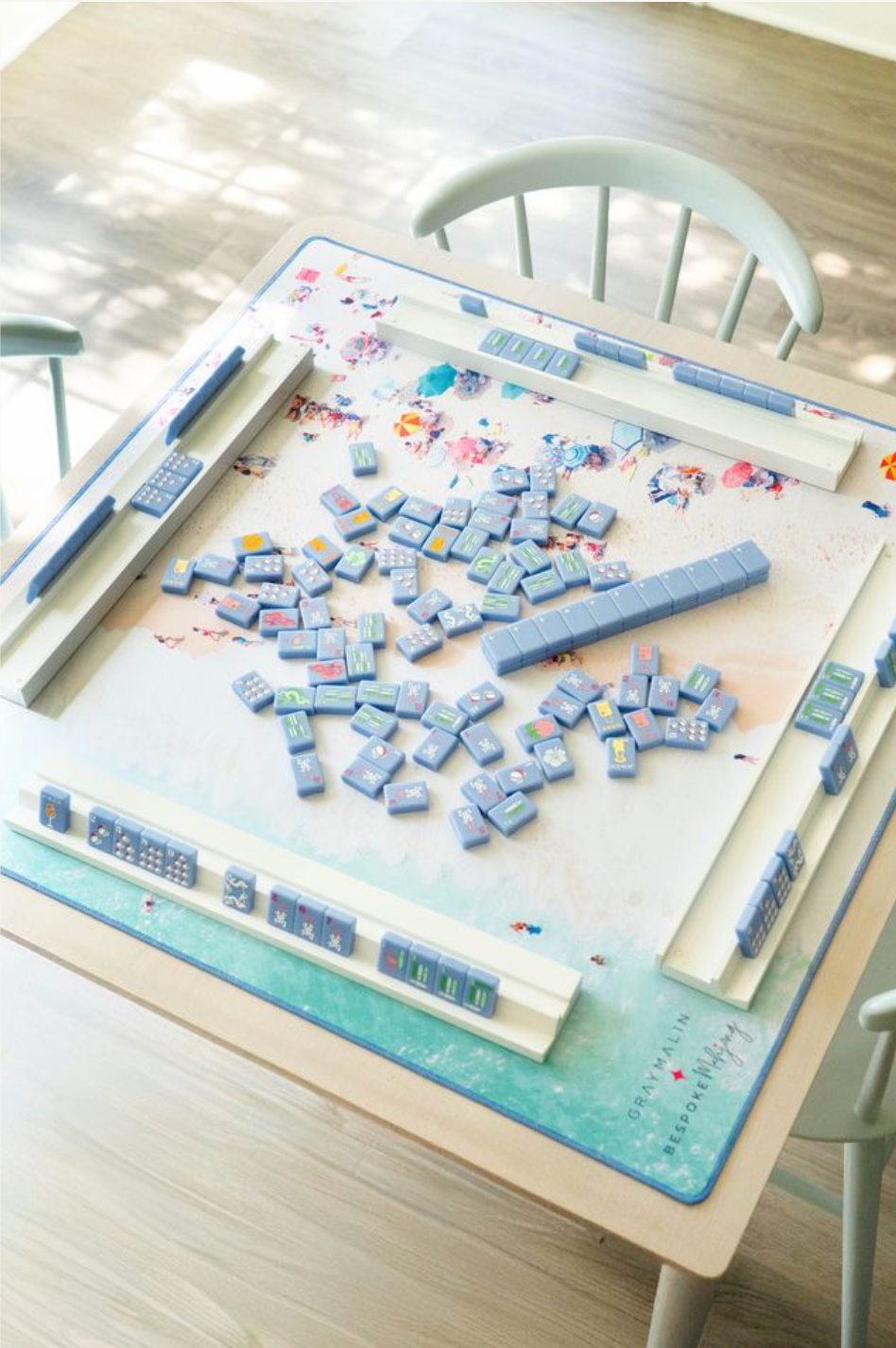Gray Malin Beach Club mat with blue tiles and racks mid-game; tiles and racks sold separately