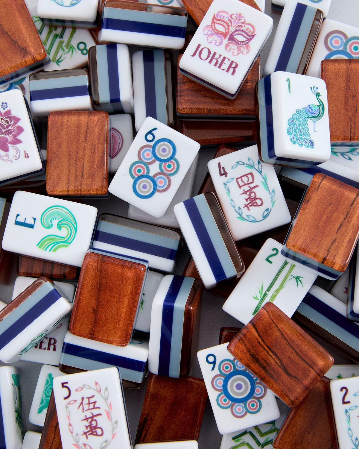 Oh My Mahjong Smith tiles piled loosely, woodgrain backs striped with navy and pale blue beside white tile faces